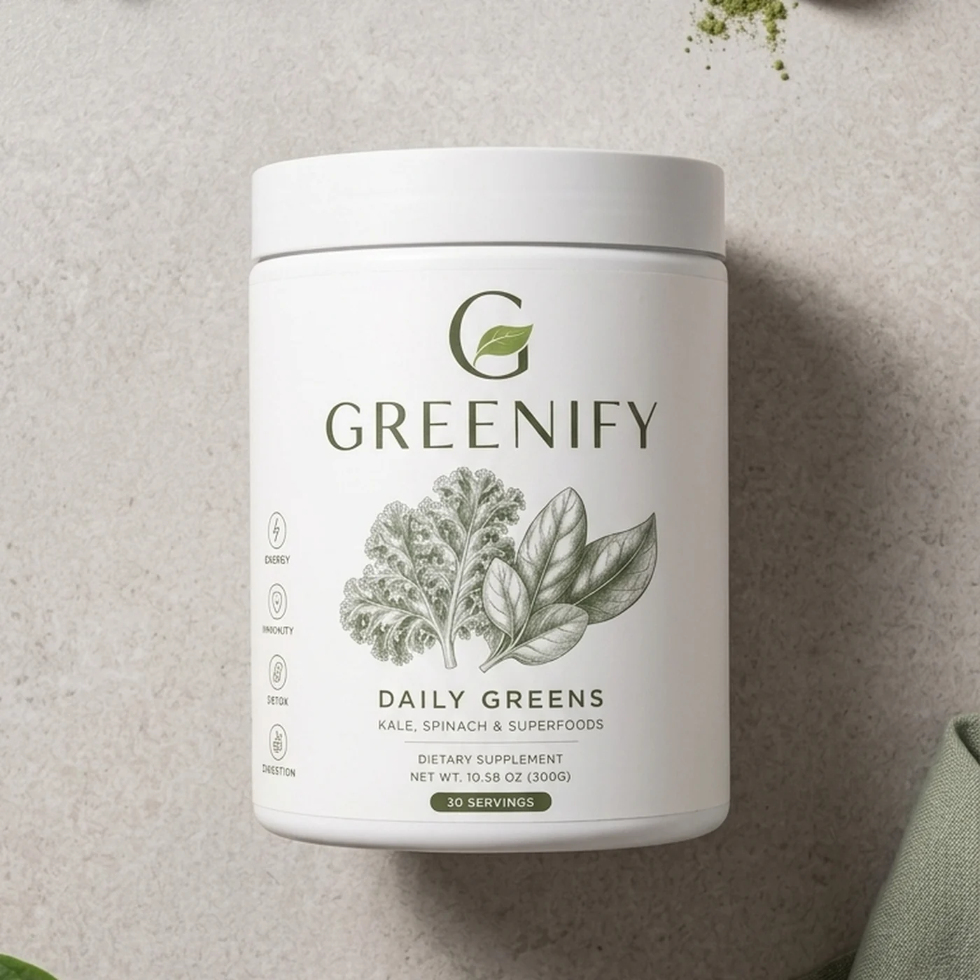 Greenify Daily Greens white tub photographed from above on a cream stone counter with fresh kale, spinach, blueberries and a wooden scoop of green powder